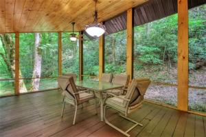 een eetkamer met een tafel en stoelen op een houten terras bij Mountain View Bliss - Cozy 1BR Cabin in Sevierville