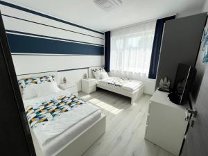 a bedroom with two beds and a tv in it at Napfény Terasz Apartman in Vonyarcvashegy