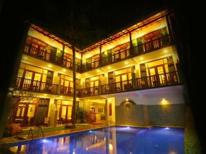 a building with a swimming pool in front of it at night at Tartaruga Beach Unawatuna in Unawatuna