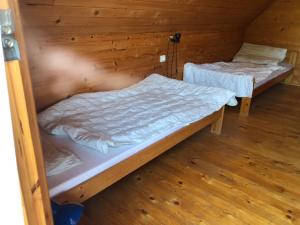 2 camas en una habitación con paredes de madera en Álmos Apartman, en Balatonfenyves