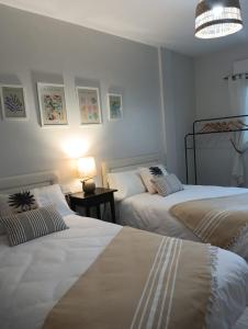 1 dormitorio con 2 camas y mesa con lámpara en Lourido playa, en Pontevedra