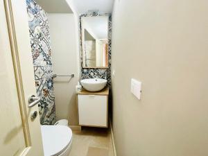 ein Badezimmer mit Waschbecken, Toilette und Spiegel in der Unterkunft CASA GIOBERTI in Castellana Grotte + 23 Fotos