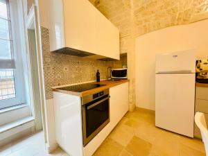 a kitchen with a sink and a refrigerator at CASA GIOBERTI in Castellana Grotte