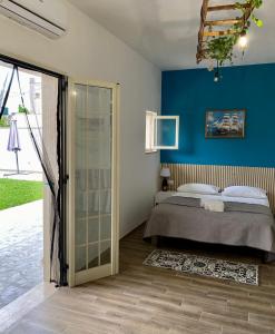 um quarto com uma cama e uma parede azul em Casa Paolina em Uggiano la Chiesa