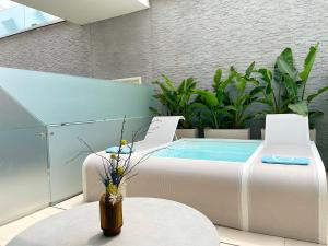 a patio with a hot tub and two chairs at Posia Retreat & Spa UNA Esperienze in San Foca