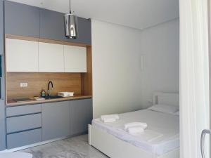 uma pequena cozinha com uma cama e um lavatório em AURA TOWER Apartments by Gaby em Rafailovici