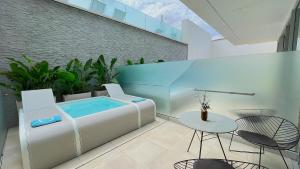 a patio with a hot tub and a table and chairs at Posia Retreat & Spa UNA Esperienze in San Foca