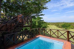 a balcony with a swimming pool and a wooden bridge at San Lameer Villa 14108 - 4 Bedroom Classic - 8 pax - San Lameer Rental Agency in Southbroom