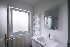 un bagno con lavandino, specchio e finestra di Cottage 110 a Wösendorf