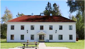 a white house with a picnic table in front of it at Oslo Airport Apartments in Gardermoen