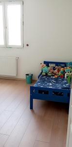a bedroom with a blue bed with stuffed animals on it at Maison au calme in Livry-Gargan