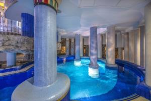 a swimming pool with columns in a hotel at Willis Hotel Business & Wellness in Zalaegerszeg