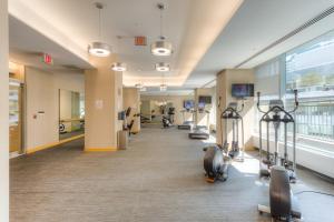 einen Fitnessraum mit Laufbändern und Crosstrainern in einem Gebäude in der Unterkunft Lakefront Retreat: Designer Suite w/Stunning Views in Toronto