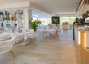 ein Esszimmer mit weißen Tischen und Stühlen in der Unterkunft Alcazaba Lagoon 2425 Luxury private beach in Estepona
