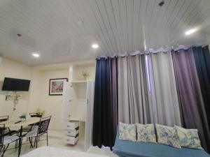 a room with a bed and a table with a dining room at Quirino Hub (401) in Davao City