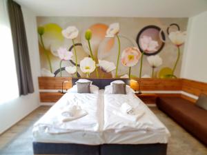 a bedroom with a white bed with flowers on the wall at Alison Apartments (Nr. 24) in Keszthely