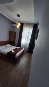a bedroom with a bed and a large window at Balu in Kobuleti