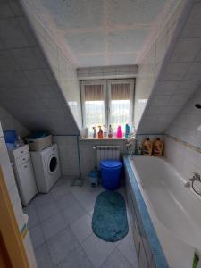 a bathroom with a tub and a washing machine at Pokoje w domu na wsi 