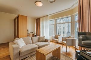 a living room with a couch and a tv at Hestia Hotel Haapsalu SPA in Haapsalu