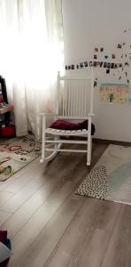 a white crib in a room with a wooden floor at Maison au calme in Livry-Gargan