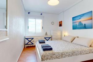 Un dormitorio con una cama con dos maletas. en Ático El Mar Mojácar- Marina de la Torre Res. Golf en Mojácar