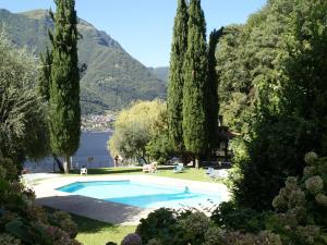 una piscina circondata da alberi e da un lago di Apartment with 2 bedrooms a large terrace with magnificent view of the lake a Pognana Lario