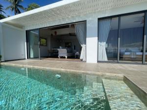 a swimming pool in front of a house at LOLISEA Luxe view villas in Salad Beach