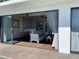 una puerta de patio abierta con sofá y mesa en LOLISEA Luxe view villas, en Salad Beach