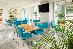 a conference room with blue chairs and tables and a flat screen tv at ibis budget Sheffield Arena in Sheffield
