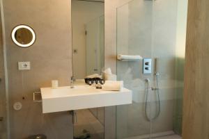 een badkamer met een wastafel en een douche bij Posia Retreat & Spa UNA Esperienze in San Foca
