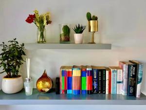 a shelf with books and potted plants on it at Elkstone Studio Private Hottub Pet Friendly in Malvern Link