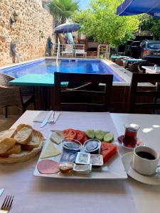 een bord eten op een tafel naast een zwembad bij Sabah Pension in Antalya