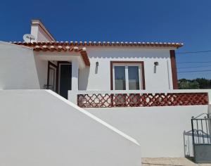 ein weißes Haus mit einer Tür und einem Zaun in der Unterkunft Alecrim d'Aldeia in Fronteira