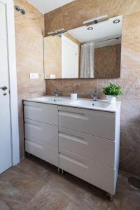 a bathroom with a white sink and a mirror at Lujoso ático entre 2 playas con garaje in Gijón
