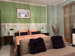 a bedroom with a large bed with purple pillows at Residence Don Turi in Villafranca Tirrena
