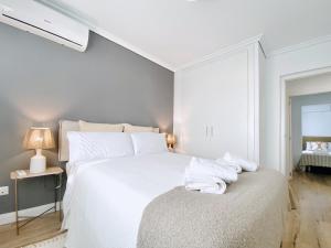 Un dormitorio blanco con una cama con toallas. en Casa Natura Sunset Beach, en Gran Alacant