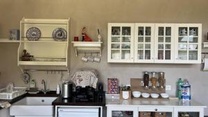 una cucina con armadi bianchi e piano di lavoro di Guest House Le Vagabonde a Fiumicino