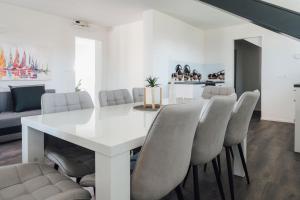 Lora & Lana Resort في ليوبليانا: غرفة طعام بيضاء مع طاولة بيضاء وكراسي