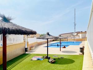 een zwembad met parasols en een zwembad bij Casa Natura Sunset Beach in Gran Alacant