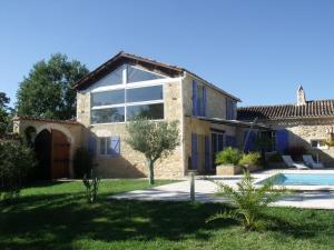 a villa with a swimming pool and a house at Aux Blanches Pierres in Fumel