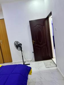 a room with a door with a fan next to it at Magnanimous Apartments 1bedroom flat at Ogudu in Lagos