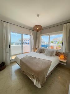 een slaapkamer met een groot bed en een groot raam bij La Duquesa Appartement 507 in Manilva
