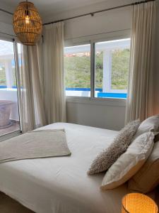 een slaapkamer met een groot bed en 2 ramen bij La Duquesa Appartement 507 in Manilva