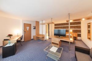 um quarto de hotel com uma televisão e uma cama em Hotel am Seegraben em Cottbus