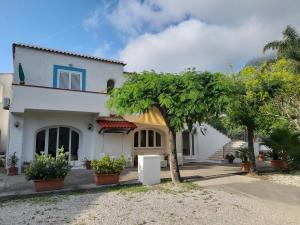 una casa blanca con árboles delante de ella en Cocos Park Ischia, en Isquia