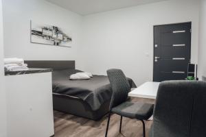 1 dormitorio con 1 cama, mesa y sillas en Lora & Lana Resort en Liubliana