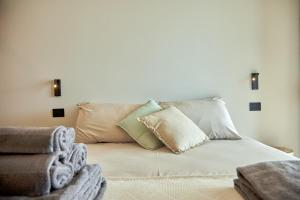 un letto con diversi cuscini in una stanza di White Coast a Polignano a Mare