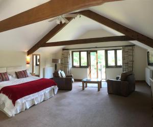 a bedroom with a large bed and two chairs at Kings Farm in Withypool