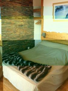 a bed in a room with a brick wall at Appartement charme CHAMROUSSE in Chamrousse