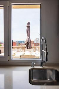 a kitchen sink and a window with a view at Lujoso ático entre 2 playas con garaje in Gijón